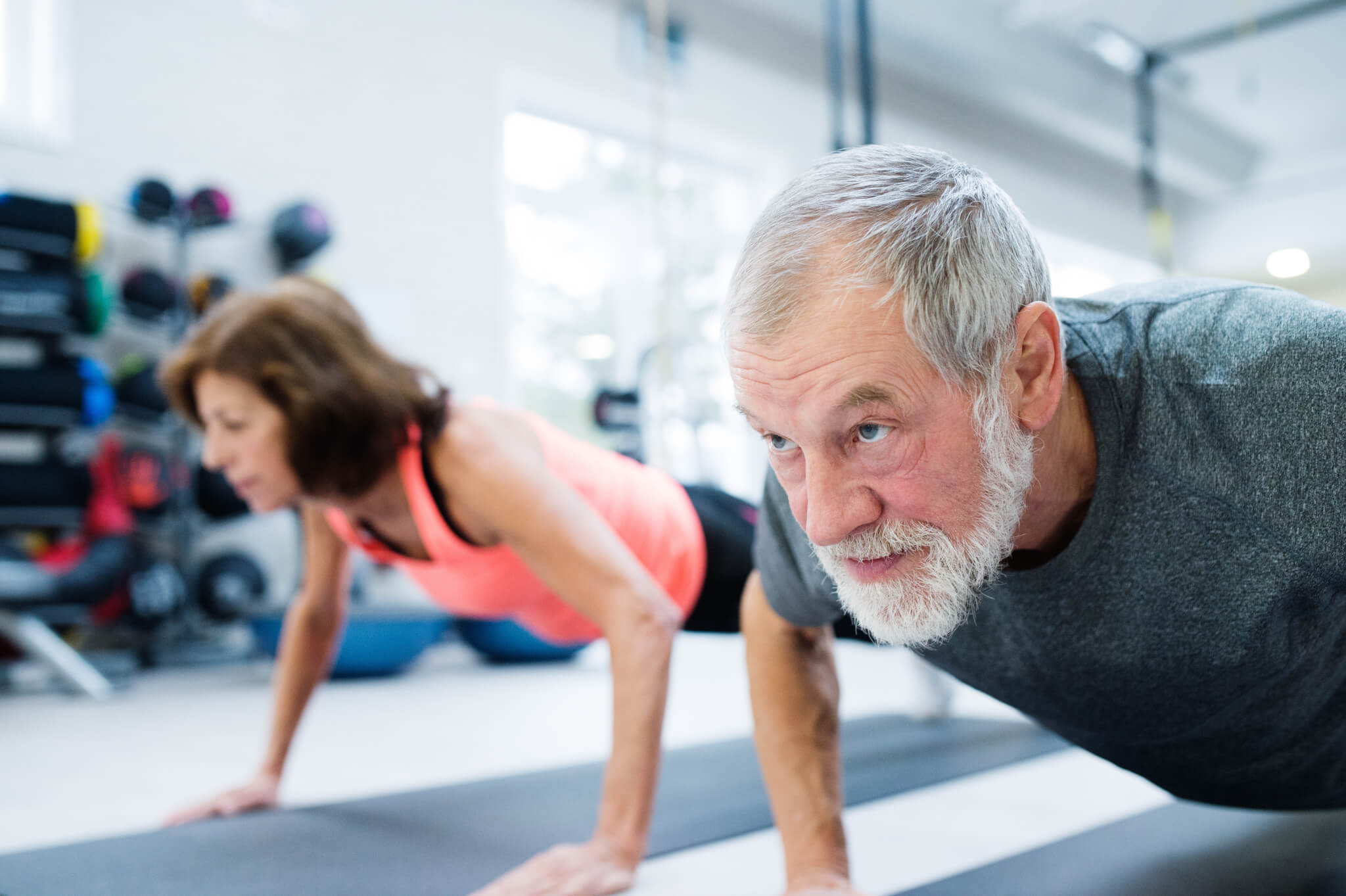 Older adults working out in the gym doing pushups