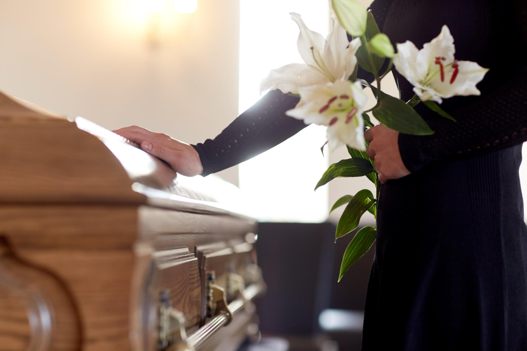 Mourner touching casket at funeral