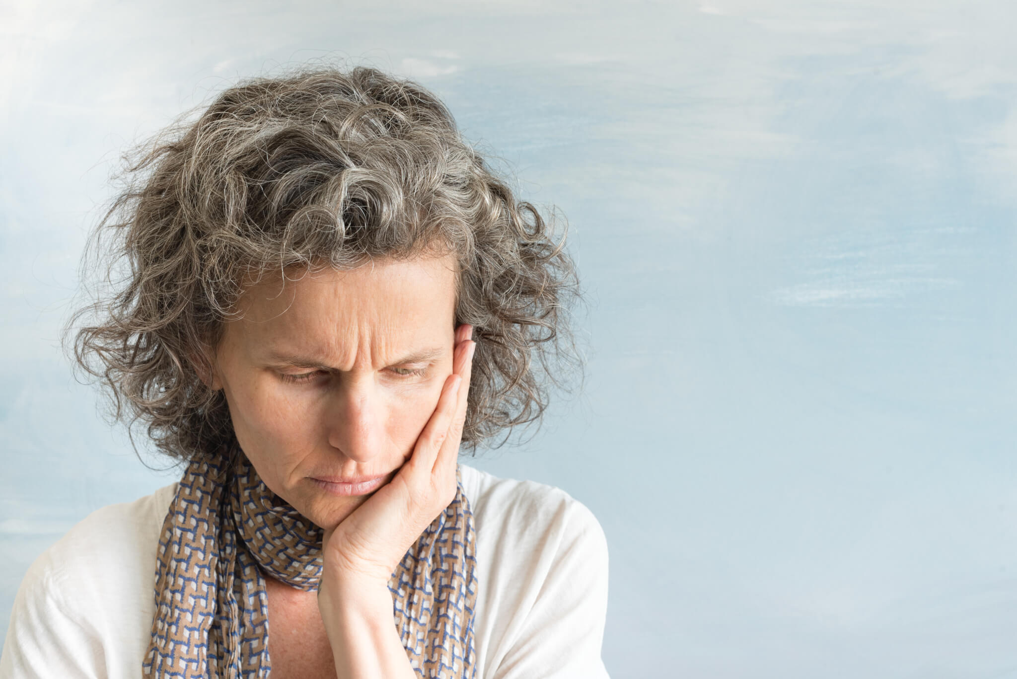 Older woman looking down, sad, stressed