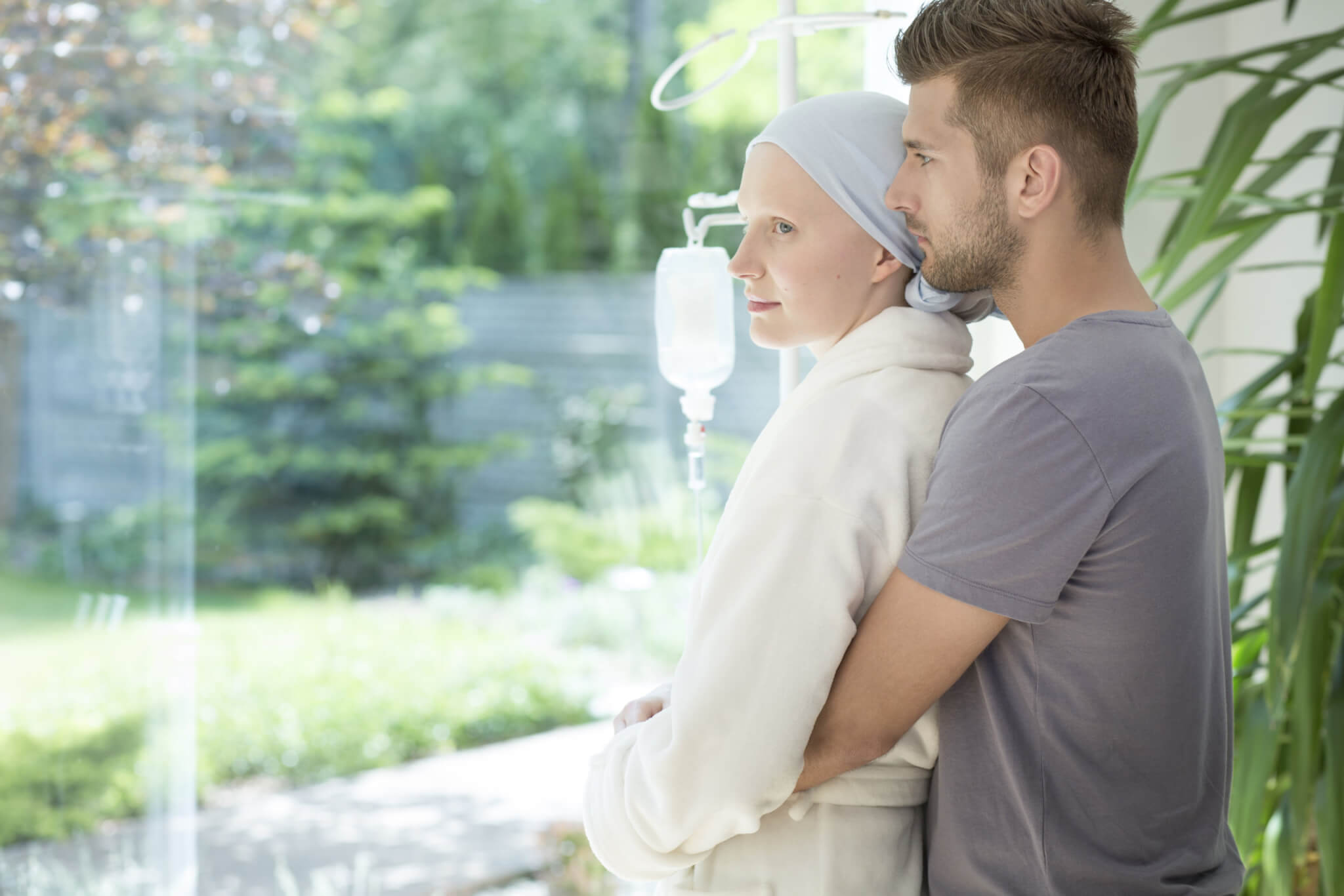 Man hugging sick girlfriend or wife with breast cancer during treatment