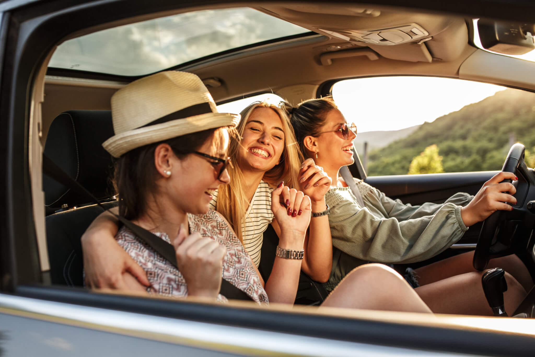 Happy teens driving in car, dancing to music