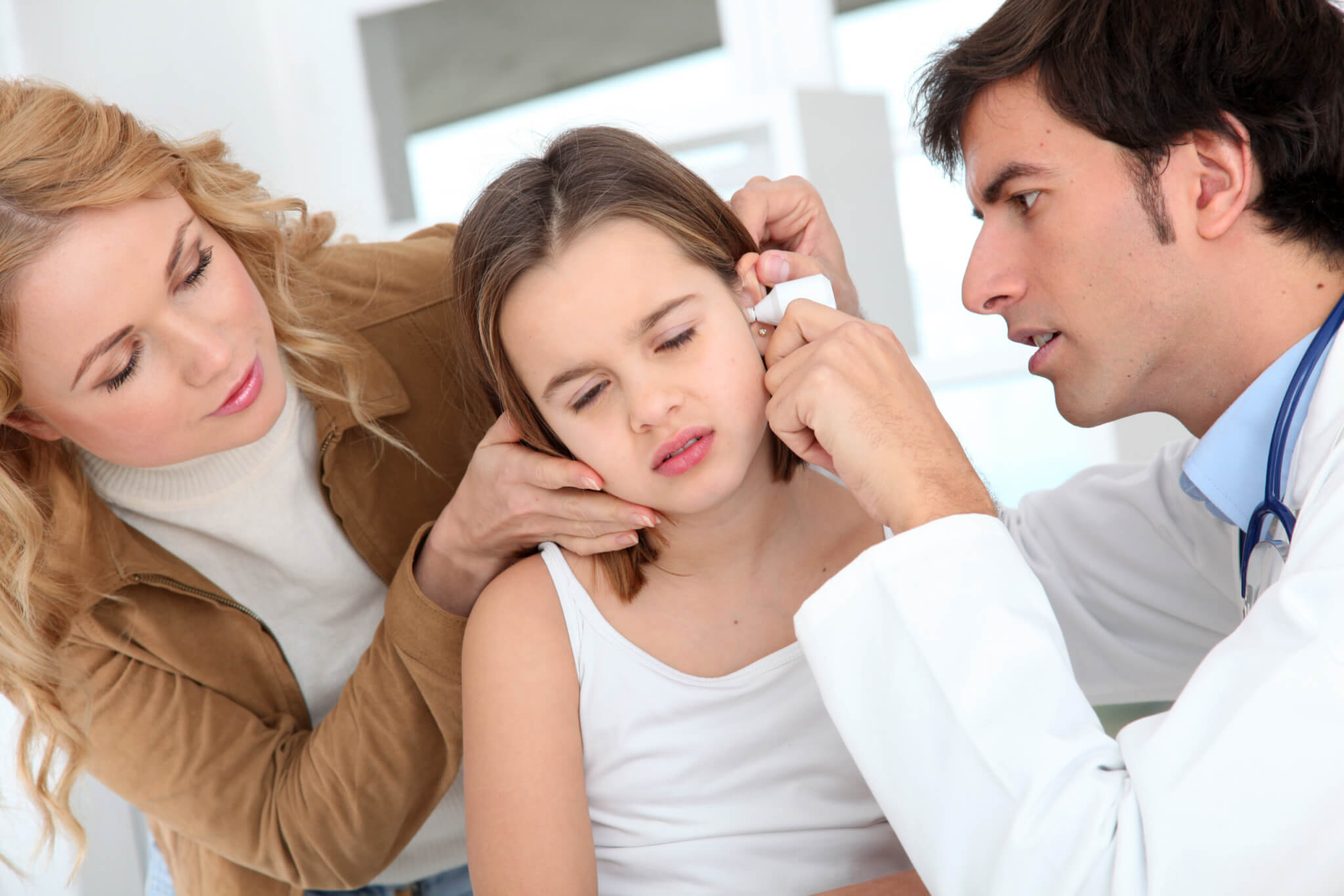 Doctor looking at little girl ear infection