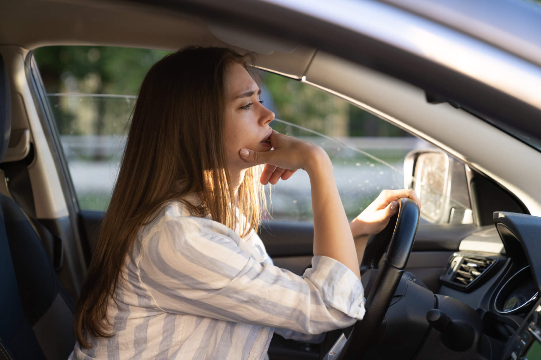 Woman driving car, tired, thinking, traffic jam