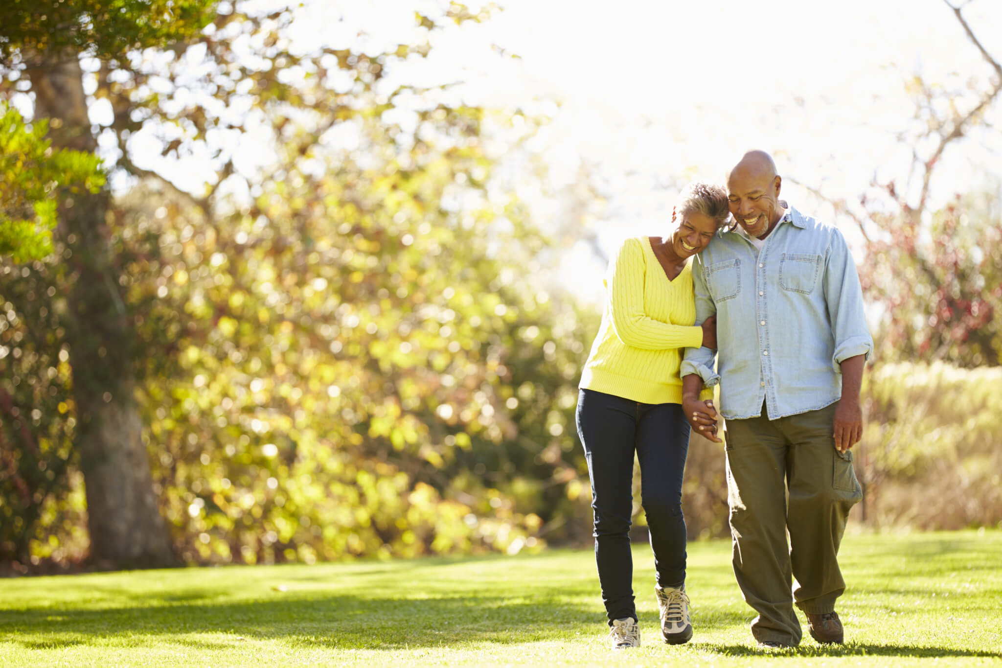 Older adults, taking walk through a park.