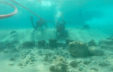 Divers on a research team examine architectural remains at the underwater village of Habonim North, off Israel's Carmel Coast.