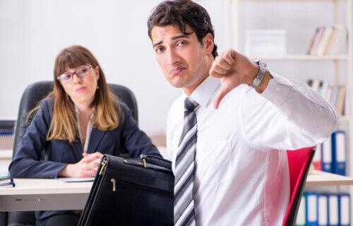 employee giving thumbs down in office