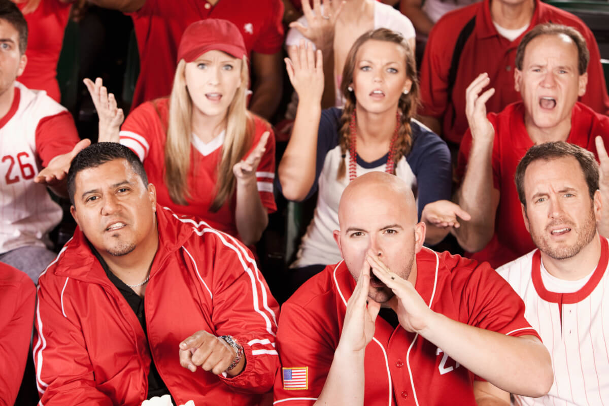 baseball fans sitting in a stadium booing.