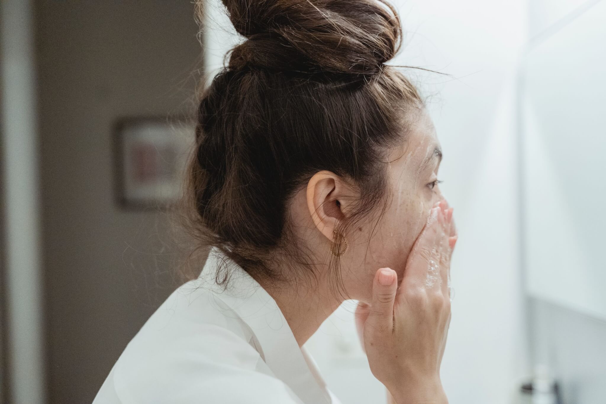 Woman washing her face in bathroom