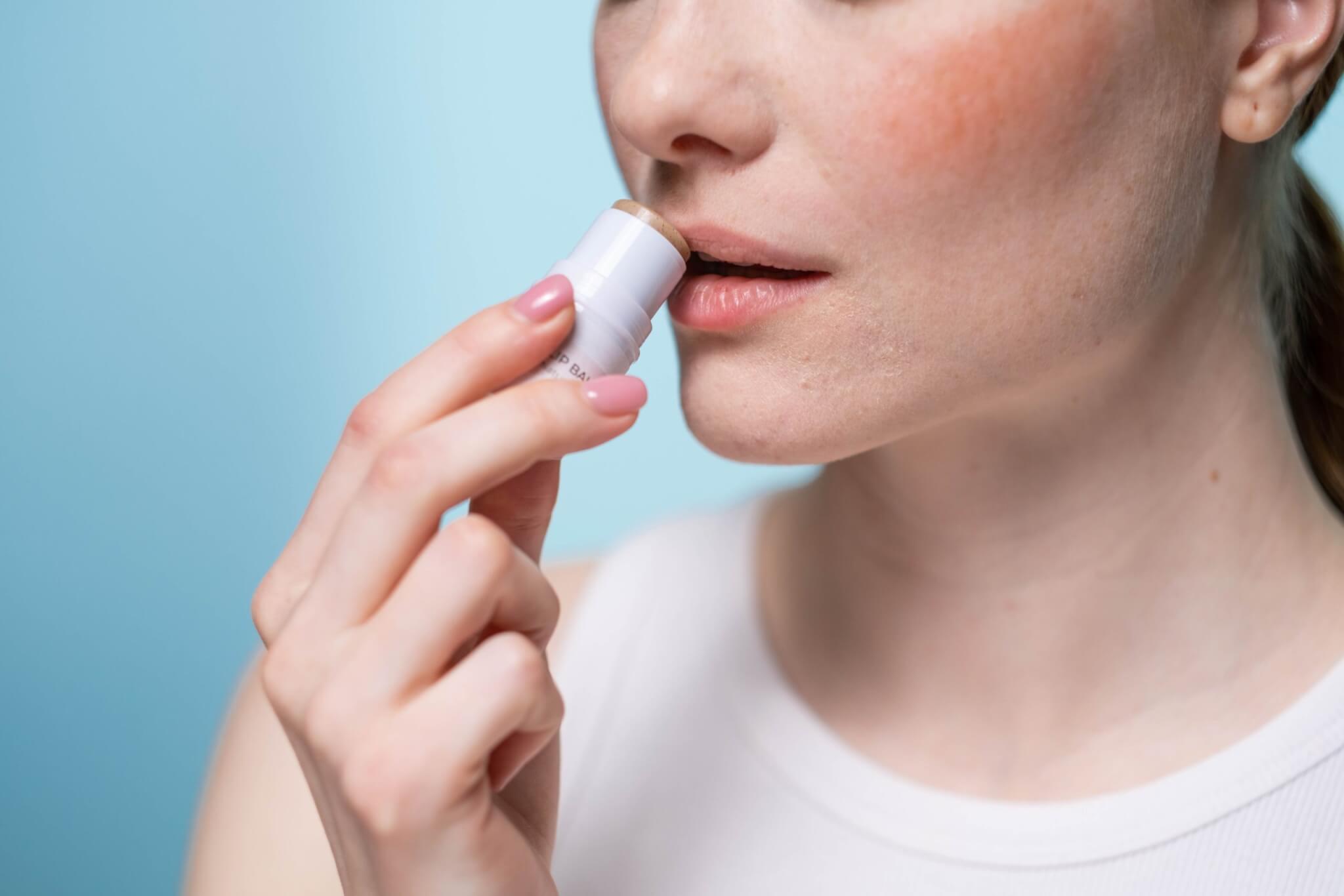 Woman applying lip balm to her lips