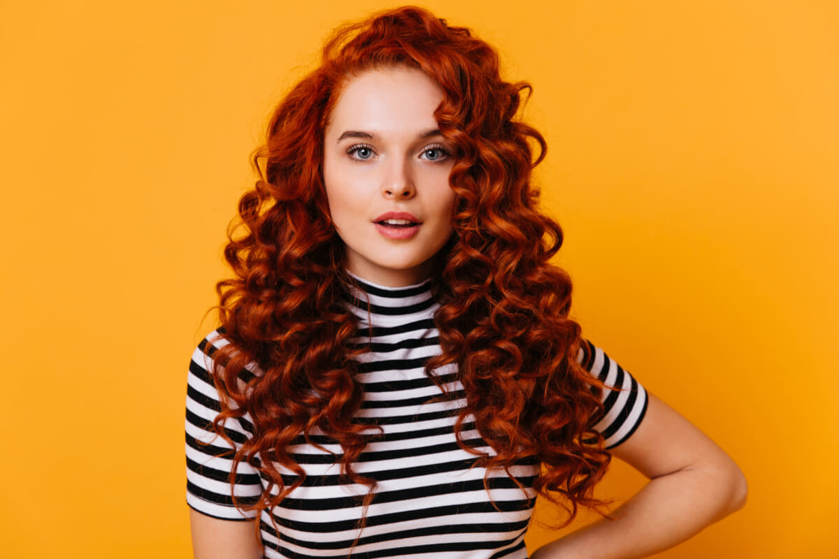 A woman with voluminous red curly hair