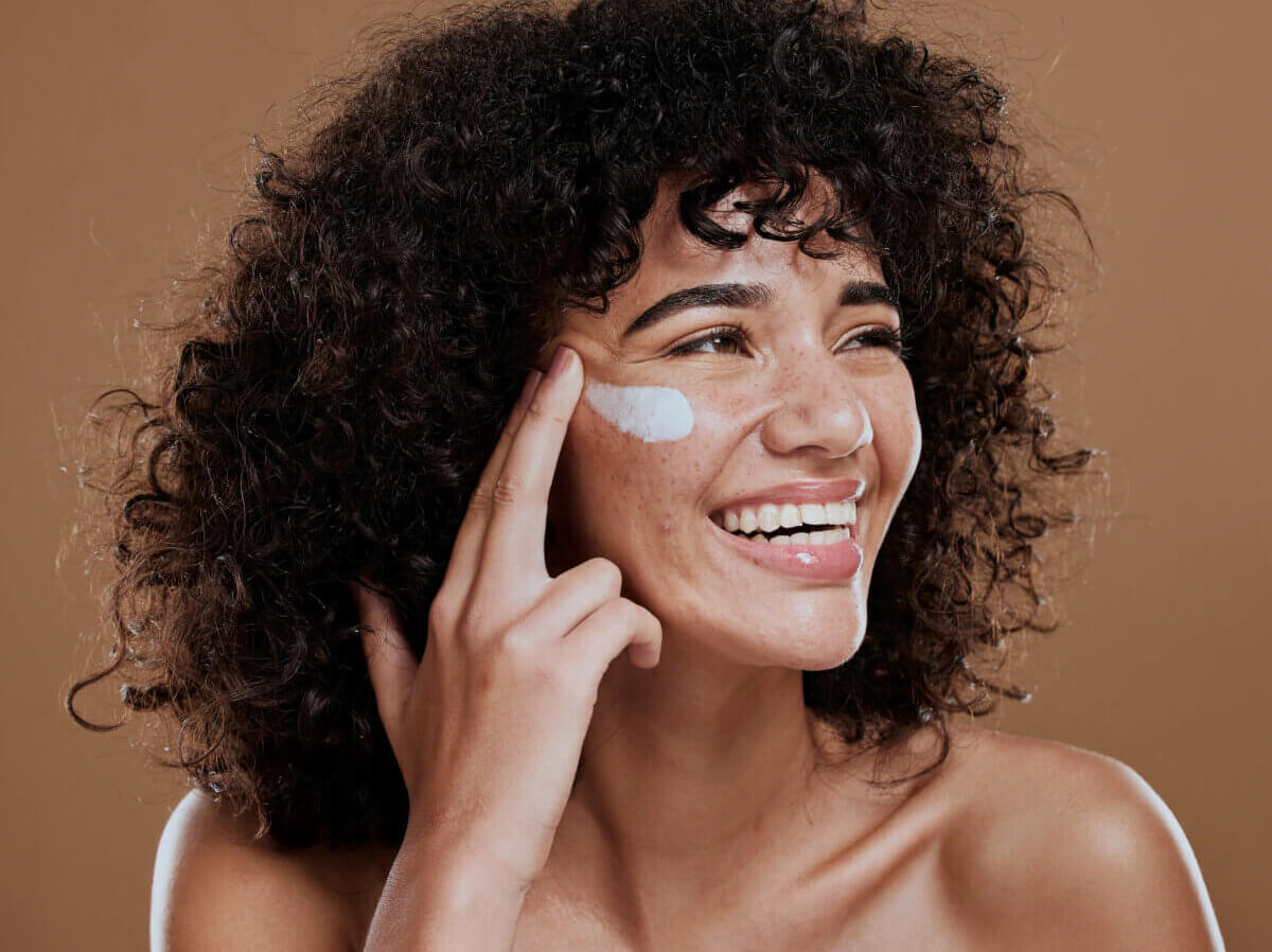 A woman applying face sunscreen