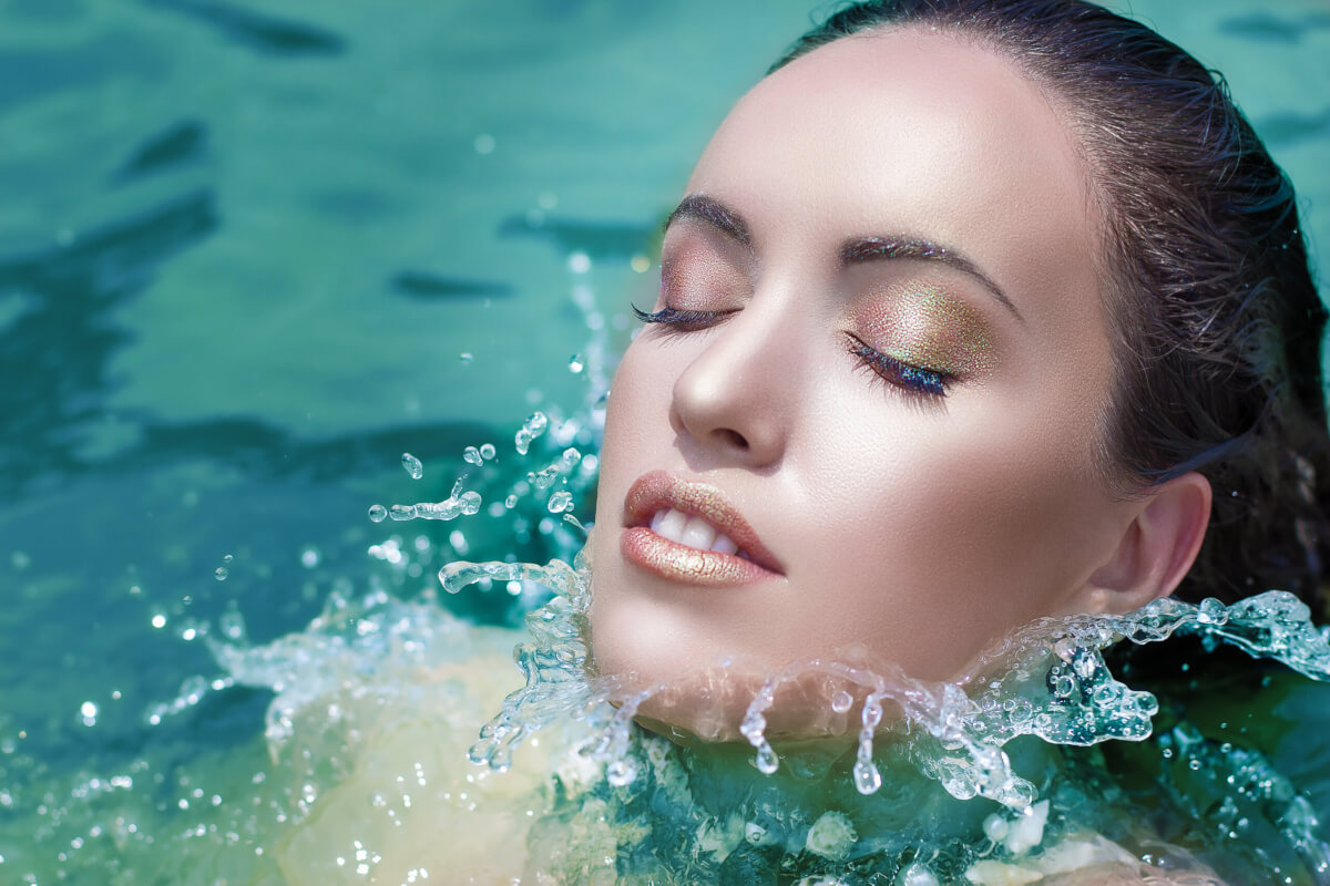 A woman swimming with a full face of makeup