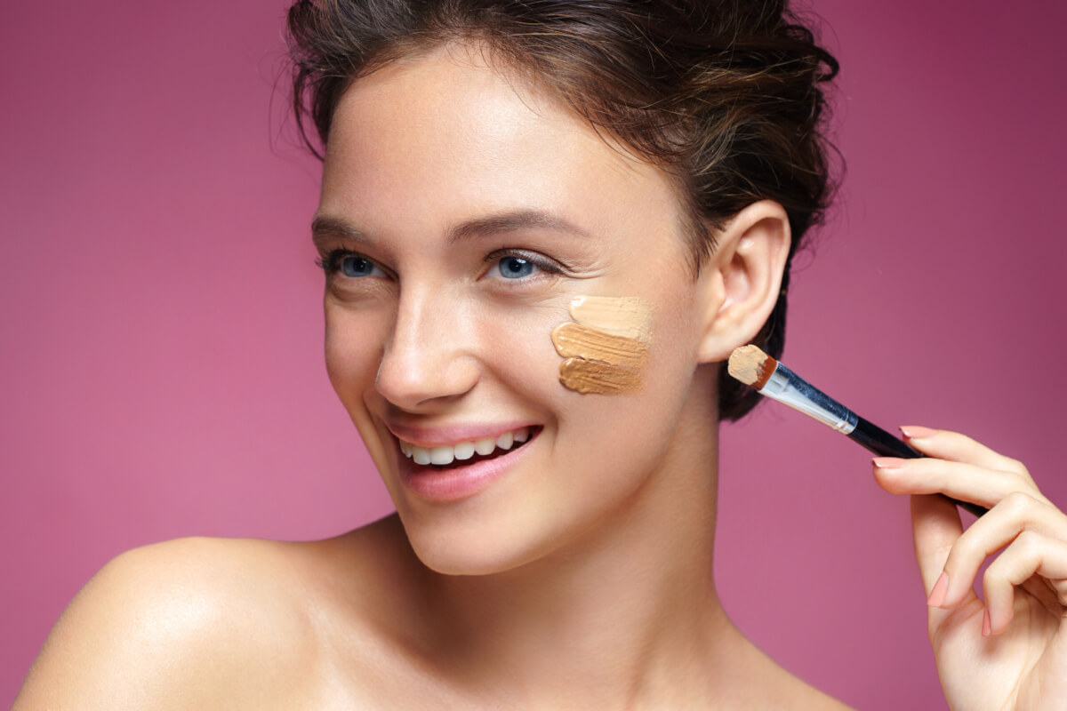 A woman applying liquid foundation