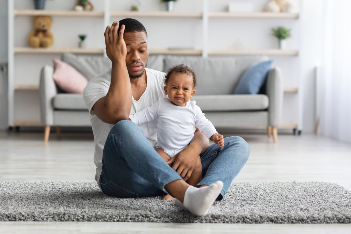 Black Father Sitting With Newborn