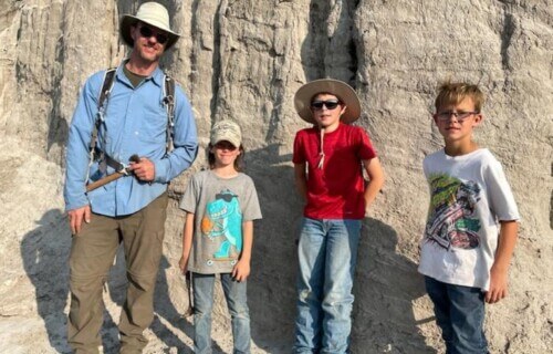 Denver Museum of Nature & Science's Curator of Paleontology Dr. Tyler Lyson and the trio of young fossil finders, Liam Fisher, Jessin Fisher, and Kaiden Madsen who discovered the remains of a juvenile T. rex skeleton while out looking for fossils with their dad Sam Fisher in North Dakota's bandlands in 2023.