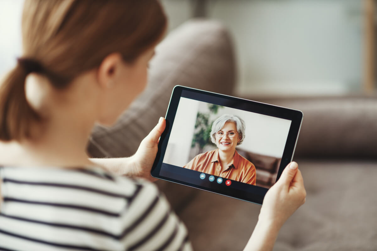 Young woman seeing video image of eldery mother