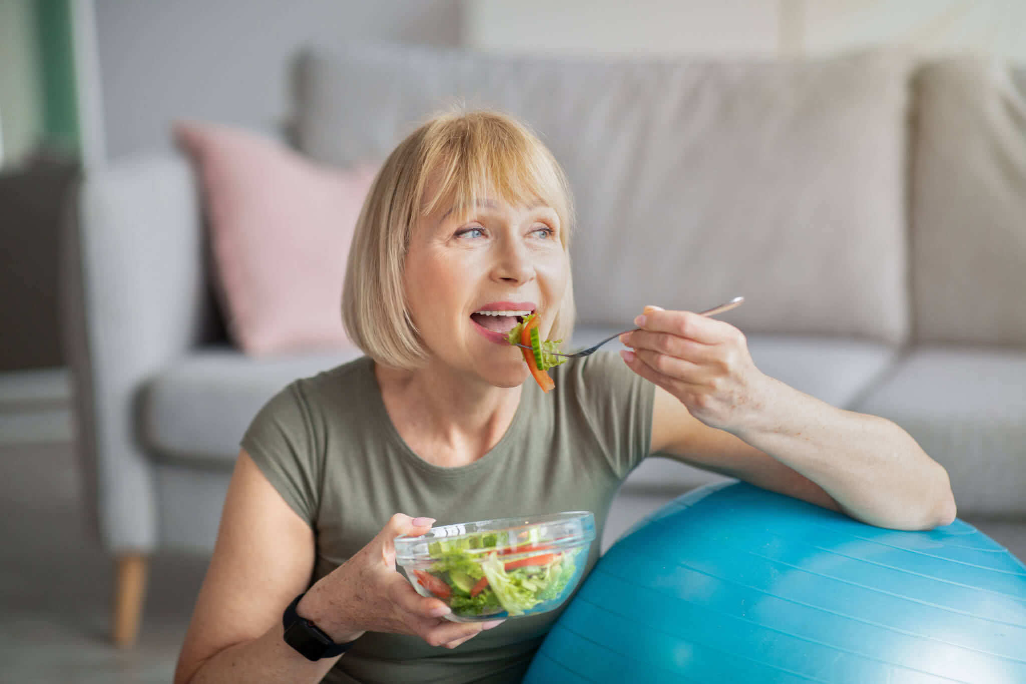 Older woman eating salad, following healthy diet and lifestyle