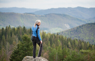 Climbing woman standing on the top of the cliff