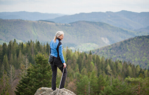 Climbing woman standing on the top of the cliff