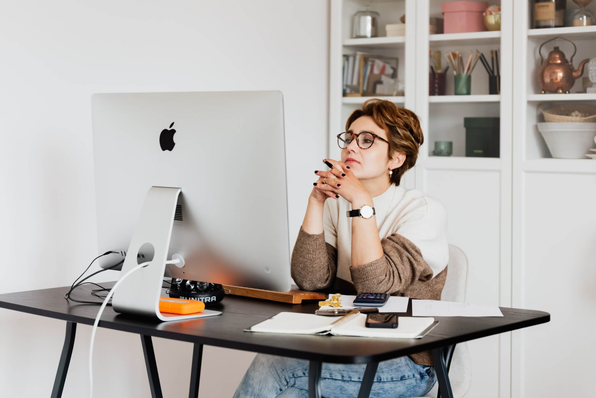 Woman sitting at her work desk looking at her computer